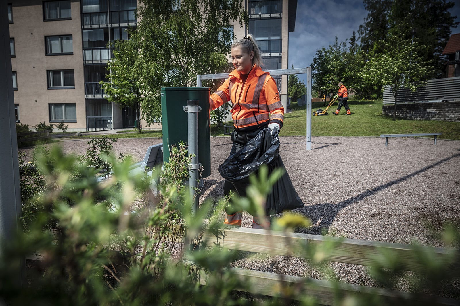 Kiinteistönhoitaja tyhjentää roskakoria