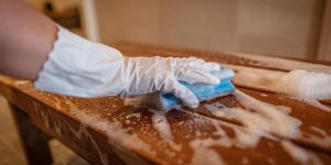 Käsi siivoaa saunan lauteita