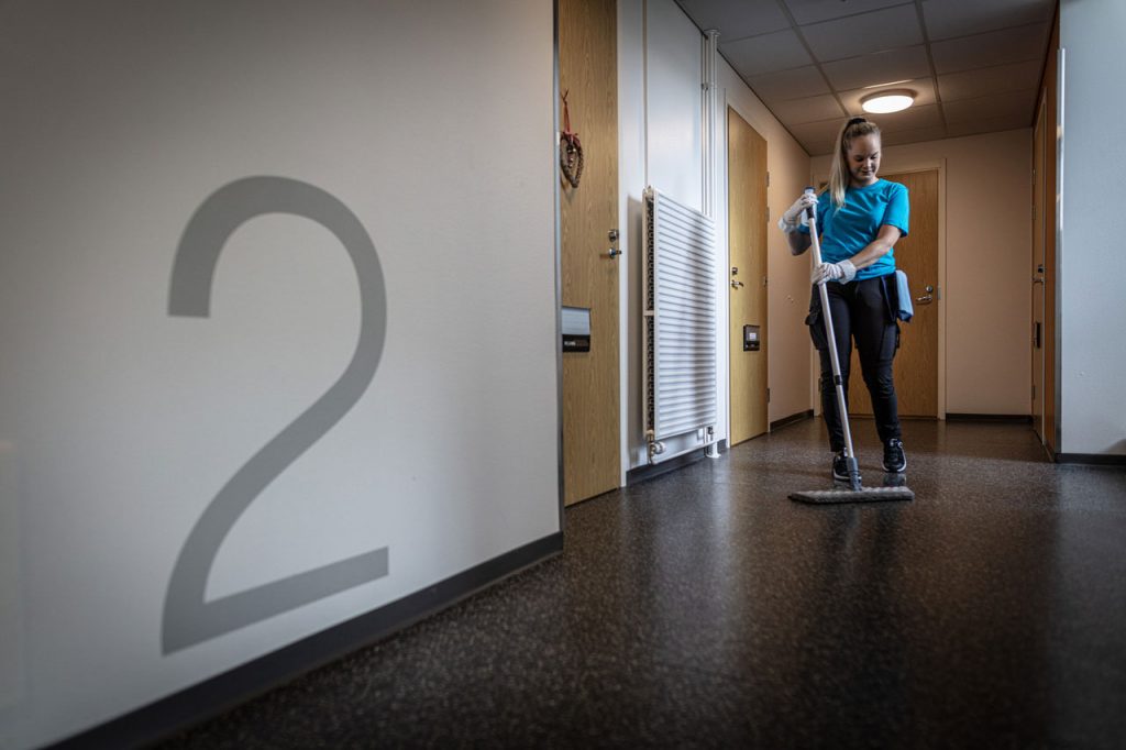 Nainen siivoaa rappukäytävää